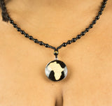 Poitrine femme porte bijou collier perle noir pendentif Afrique doré sous cercle noir 